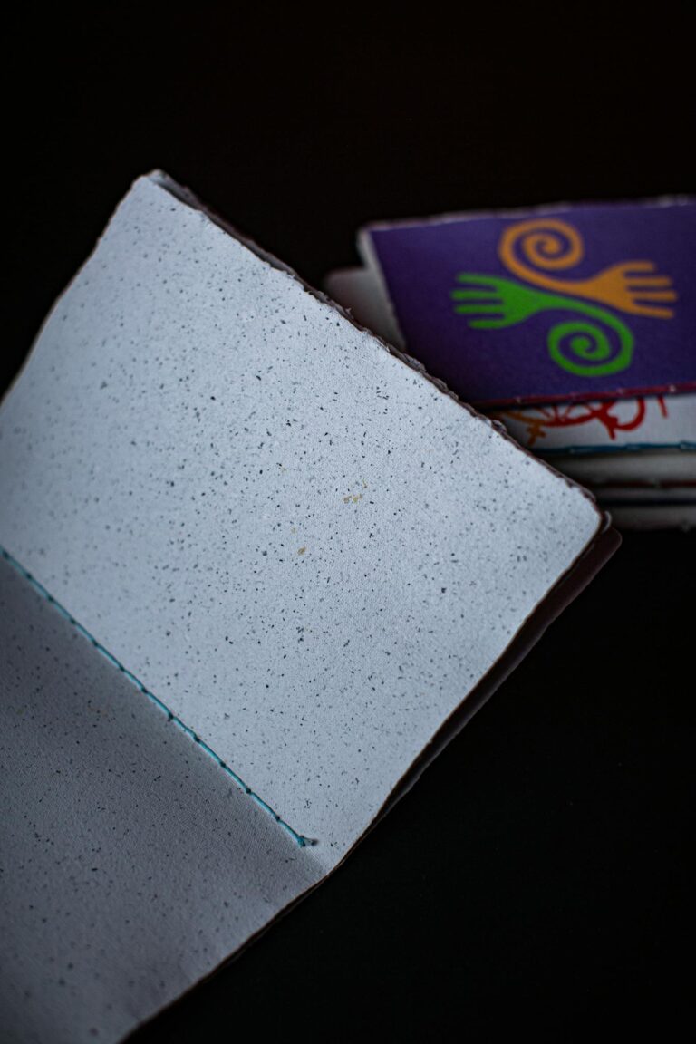 Blank notebook with speckled pages and a colorful, artistic cover, perfect for creativity or journaling.